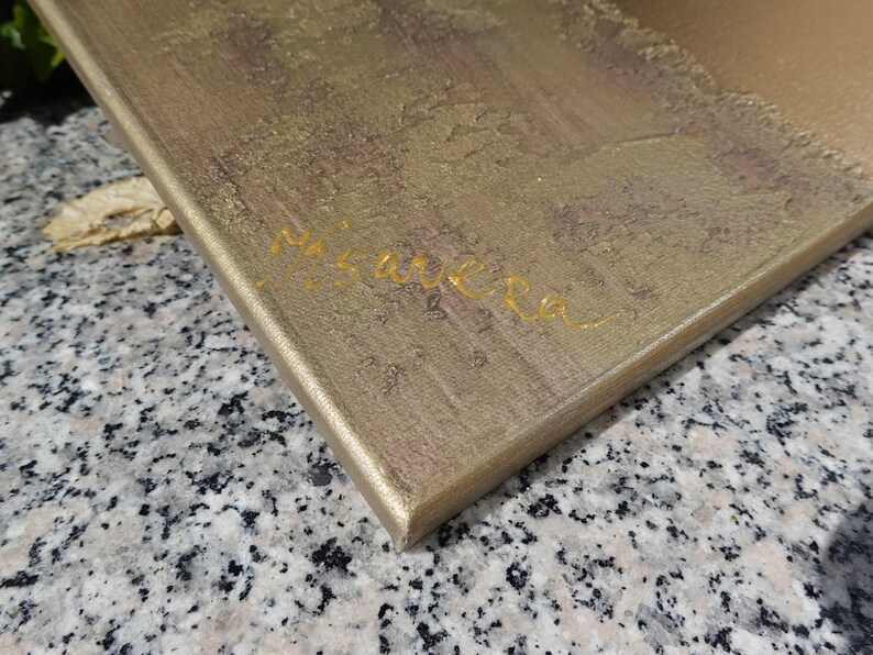 a close-up view of a textured surface, possibly a wooden board or a piece of paper, with the name "Miguel" written on it in cursive.