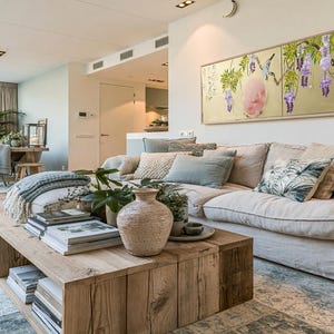 a cozy and well-decorated living room with a large window, a comfortable sofa, a wooden coffee table, and various decorative elements such as potted plants, vases, and books.