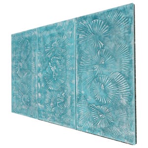 The image is a three-panel artwork with a blue and white color scheme. The panels feature intricate designs of seashells or other marine life, creating a visually striking and textured composition.