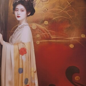 May include: A woman in a white and gold robe with red and blue floral patterns. She is wearing a traditional headdress with a pearl design. The background is a red and gold canvas with abstract designs.