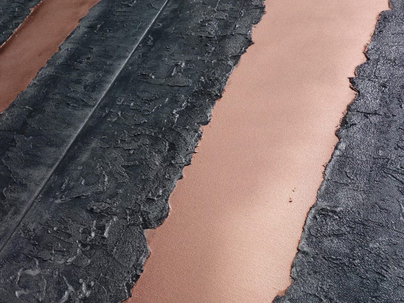 a close-up view of a textured surface with a striped pattern, featuring a mix of black and pink colors.