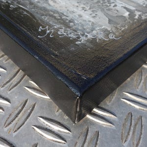 a close-up view of a black, textured surface with a metal plate pattern.