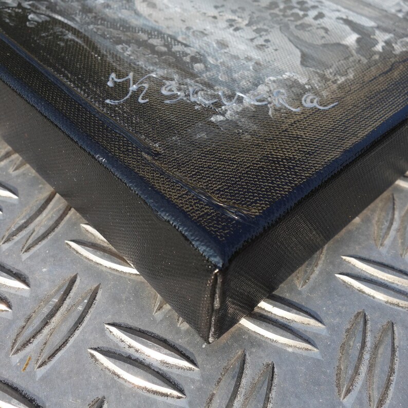 a close-up view of a black, textured surface with a metal plate pattern.