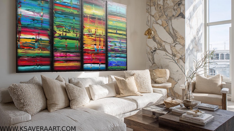 a modern living room with a large, colorful abstract painting on the wall. The room has a white sofa, a wooden coffee table, and a large window that provides a view of the city.