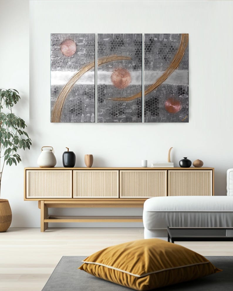 a modern living room with a large abstract painting on the wall, a wooden cabinet, and a comfortable seating area with a yellow pillow.