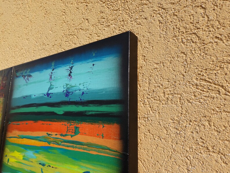 The image is a vibrant abstract painting with bold colors and brushstrokes, displayed on a wall.