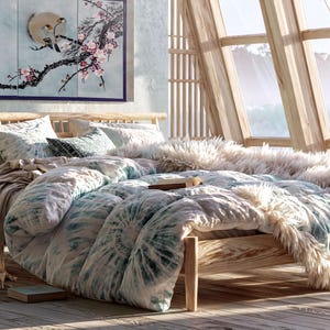a serene and cozy bedroom with a large bed, a wooden headboard, and a large window overlooking a scenic view. The room is decorated with a mix of natural and modern elements, including a potted plant, a vase, and a framed artwork on the wall. The overall atmosphere of the room is warm and inviting, with a harmonious blend of colors and textures.
