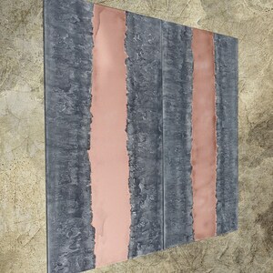 a square-shaped metal panel with vertical stripes in shades of gray and pink.