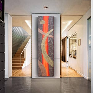 a modern hallway with a large abstract painting on the wall, a staircase, and a glass door leading to another room.