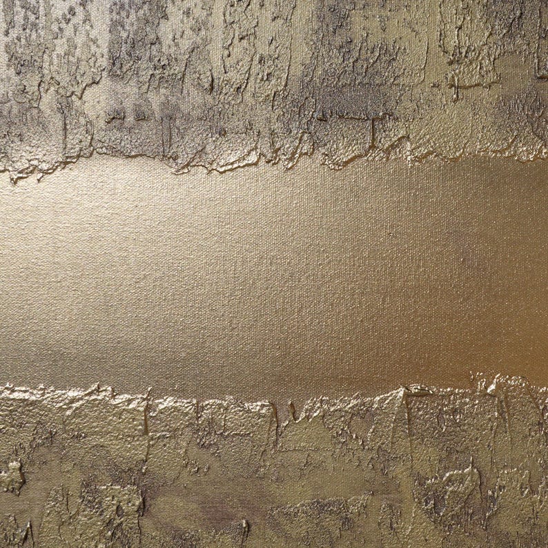 The image is a close-up of a textured surface with a golden or metallic sheen, featuring a rough, uneven texture with visible cracks and crevices.