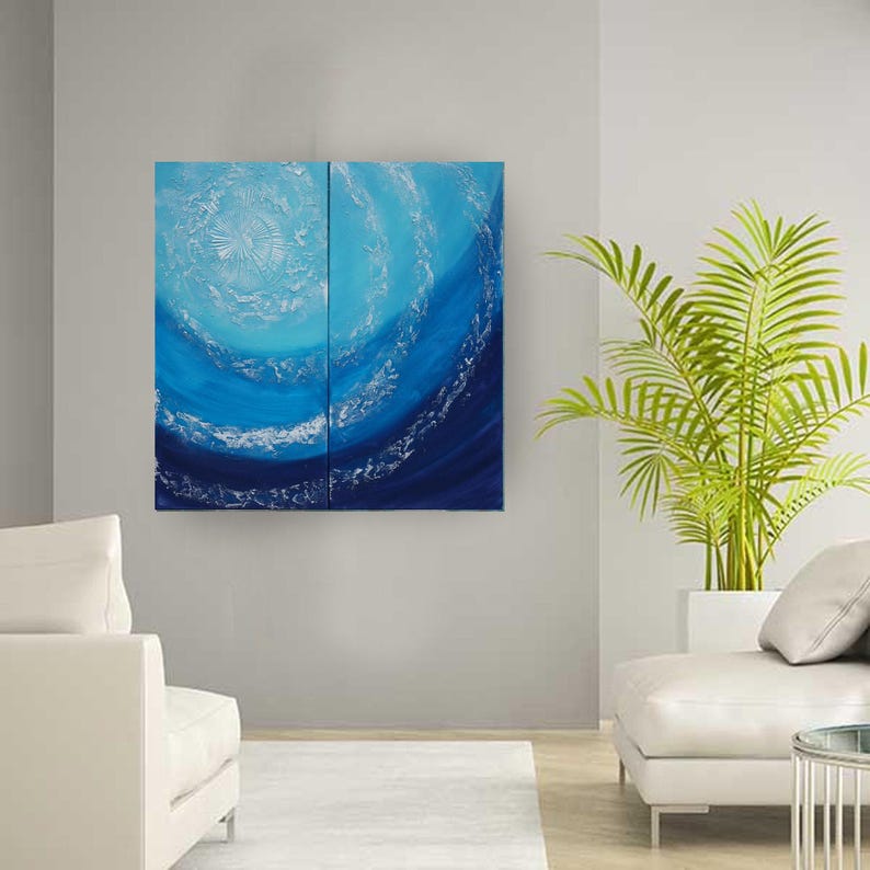 a modern living room with a large abstract painting of blue and white waves hanging on the wall. The room is furnished with a white sofa and a chair, and there is a potted plant in the corner.