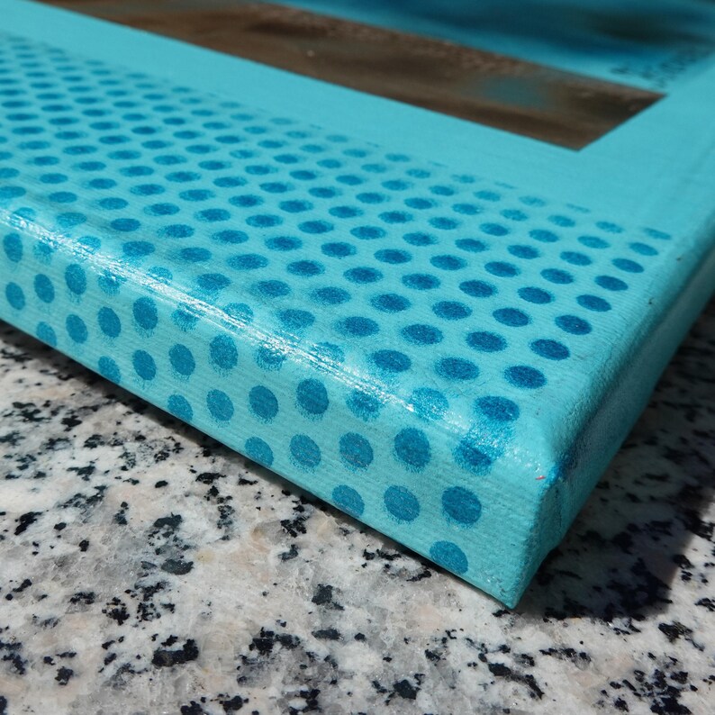 a close-up view of a blue and white polka dot pattern on a surface, possibly a piece of paper or a canvas.
