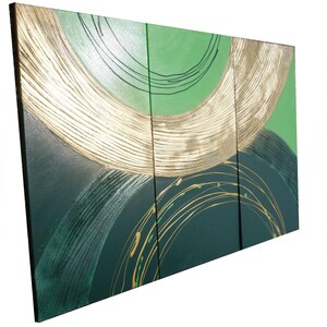 The image is a triptych of abstract artworks, featuring a combination of green and gold colors. The artwork is composed of three distinct panels, each with its own unique design and pattern. The overall composition creates a visually striking and dynamic display.