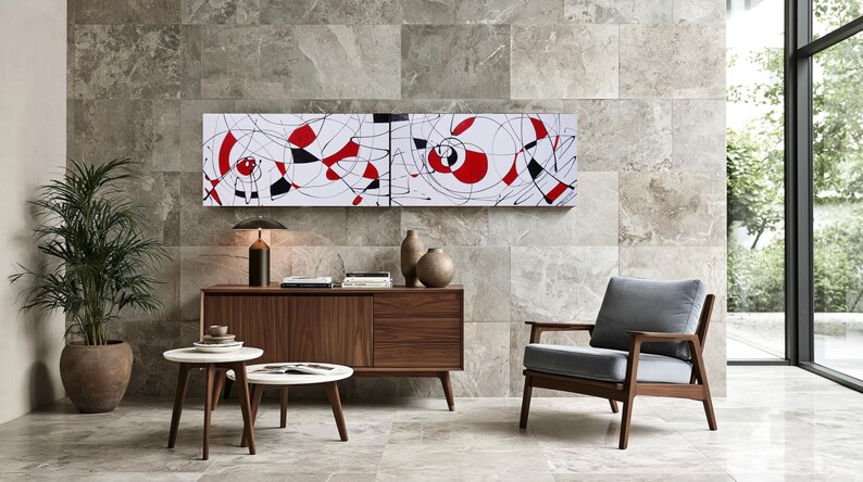 a modern living room with a large abstract painting on the wall, a wooden sideboard with a lamp and decorative items, a gray armchair, and a round coffee table.