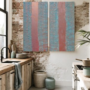 a cozy and well-decorated kitchen with a rustic wooden counter, a large window, and a colorful abstract painting on the wall.