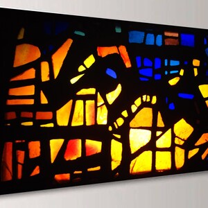 The image is a vibrant and colorful abstract artwork, featuring a variety of geometric shapes and patterns in shades of orange, yellow, blue, and black.