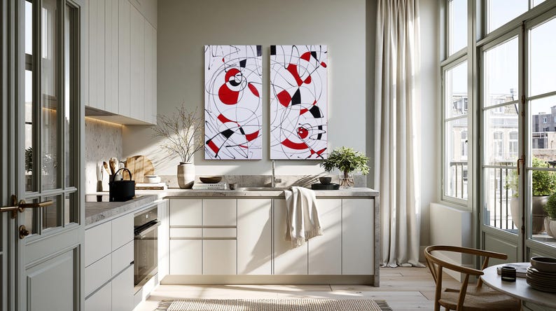 a modern kitchen with white cabinets, a large abstract painting on the wall, and a dining table with chairs.
