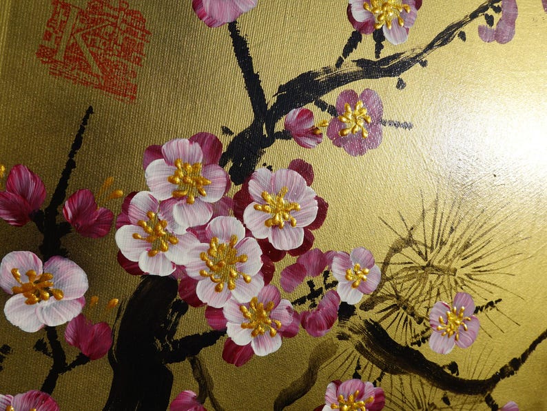 a close-up view of a painting of pink and white flowers on a gold background.