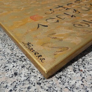 a close-up view of a textured surface, possibly a canvas or a wooden board, with some writing or markings on it.