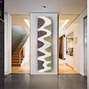 a modern hallway with a large abstract painting hanging on the wall. The hallway has a wooden floor and white walls, creating a clean and minimalist aesthetic.