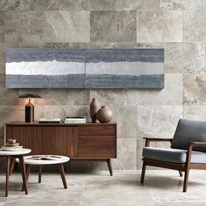 a modern living room with a large window, a wooden sideboard, a gray armchair, a wooden coffee table, and a potted plant.