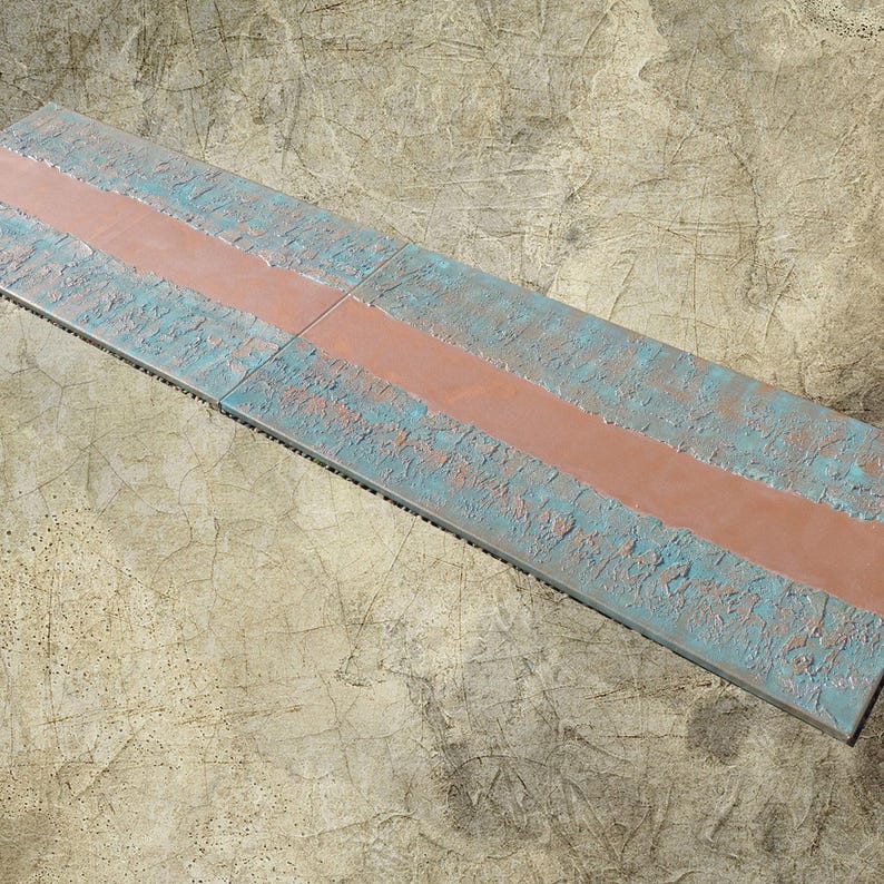 a long, narrow, and weathered surface with a horizontal line running through it. The surface appears to be made of concrete or a similar material, with a faded and worn appearance.