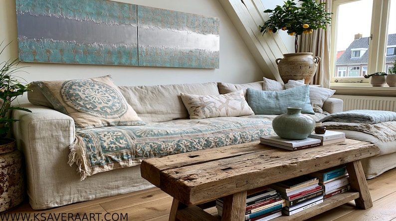 a cozy living room with a large window, a comfortable sofa with patterned pillows, a wooden coffee table, and a bookshelf filled with books.