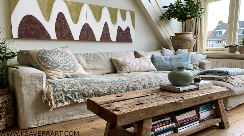 a cozy living room with a large window, a comfortable couch with patterned pillows, a wooden coffee table, and a bookshelf filled with books.