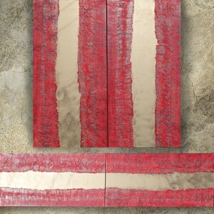 a striking abstract artwork composed of bold red and white stripes. The artwork is displayed on a concrete wall, creating a visually striking contrast between the vibrant colors and the rough texture of the wall.