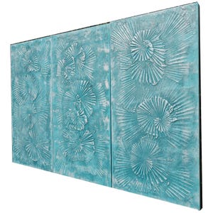The image is a triptych of three paintings, each featuring a blue background with white floral designs. The paintings are arranged in a row, creating a visually appealing and harmonious display.