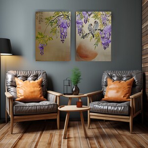 a cozy living room with two leather armchairs, a wooden coffee table, and two framed paintings of purple flowers hanging on the wall above the seating area.