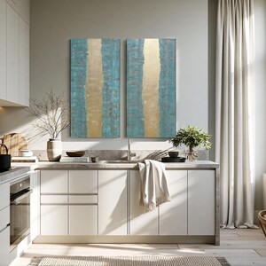 a modern, well-lit kitchen with white cabinets, a large window, and a striking abstract painting on the wall.