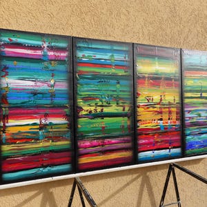 a vibrant, abstract painting with bold, colorful brushstrokes arranged in a grid-like pattern on a wall.