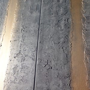 a close-up view of a textured surface with vertical lines, possibly metal or concrete, creating a sense of depth and dimension.