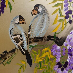 two birds perched on a branch, surrounded by a lush, colorful backdrop of purple flowers and green leaves.