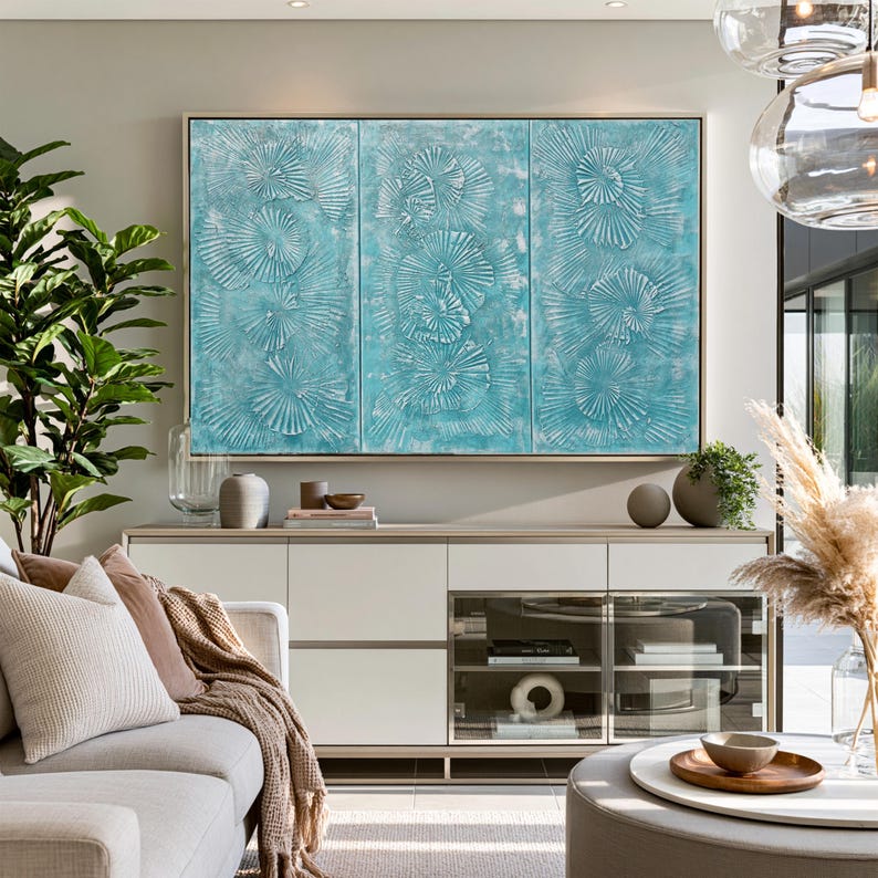 a modern living room with a large turquoise abstract painting on the wall, a white sofa, a glass-fronted entertainment unit, and various decorative elements such as a potted plant, vases, and a bowl.