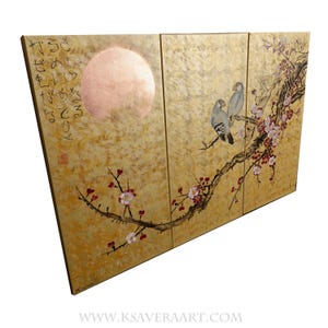 The image is a three-panel artwork featuring a large pink moon, two birds perched on a branch with flowers, and a golden background.
