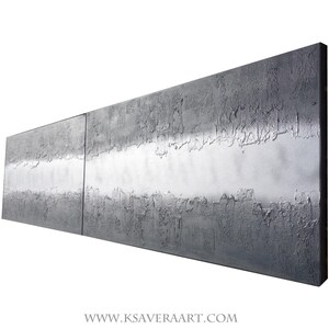 The image is a large, rectangular, metallic surface with a textured, metallic appearance. It is set against a white background, which highlights its metallic properties. The image does not contain any discernible text or other objects, and it is not a collage of multiple images. The image is a single, continuous piece of artwork.