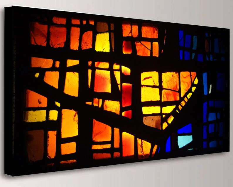 The image is a vibrant, abstract stained glass artwork with a colorful, geometric design. The glass pieces are arranged in a way that creates a striking visual effect, with warm and cool colors blending together to form a dynamic and eye-catching composition.