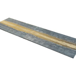 a long, narrow, and textured surface with a horizontal line running through it. The surface appears to be made of metal or a similar material, with a distinct pattern or texture.