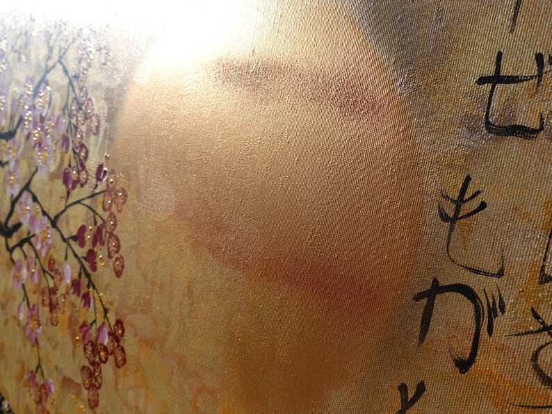 The image is a close-up of a textured surface with a golden hue, featuring a floral design and some Japanese characters.