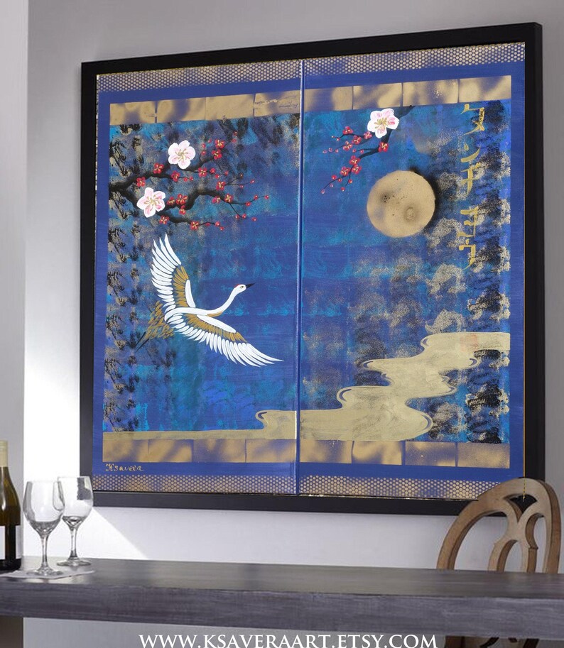 a large, colorful painting of a crane in flight against a night sky backdrop, with cherry blossoms and a full moon. The painting is framed and hangs on a wall, with a wooden chair and a bottle of wine visible in the foreground.