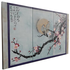 The image is a three-panel Japanese-style artwork featuring a pair of birds perched on a branch with flowers. The panels are arranged in a vertical format, with the top and bottom panels showing the birds and the middle panel depicting the branch with flowers. The artwork is framed by a purple border, and there is Japanese text written in the top left corner.