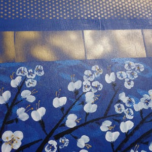 The image is a close-up of a painting featuring white flowers with gold accents against a blue background.