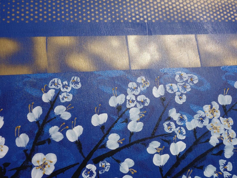 The image is a close-up of a painting featuring white flowers with gold accents against a blue background.