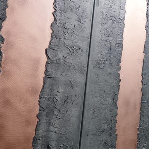 a close-up view of a textured surface with vertical lines and a metallic sheen, creating a visually striking contrast between the dark and light elements.