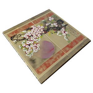 a square-shaped piece of art with a floral design, including a tree with pink flowers and a large pink flower.