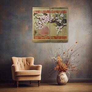 a cozy living room with a beige armchair, a vase of dried flowers, and a framed artwork of a cherry blossom tree on the wall.