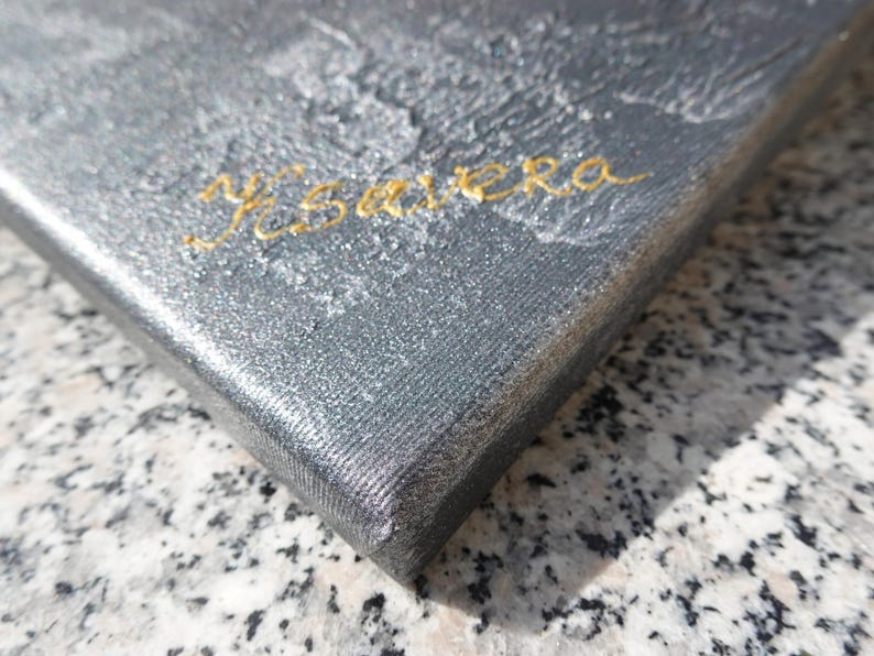 a close-up view of a textured surface, possibly a piece of artwork or a fabric, with the word "Ysaya" written in cursive on it.