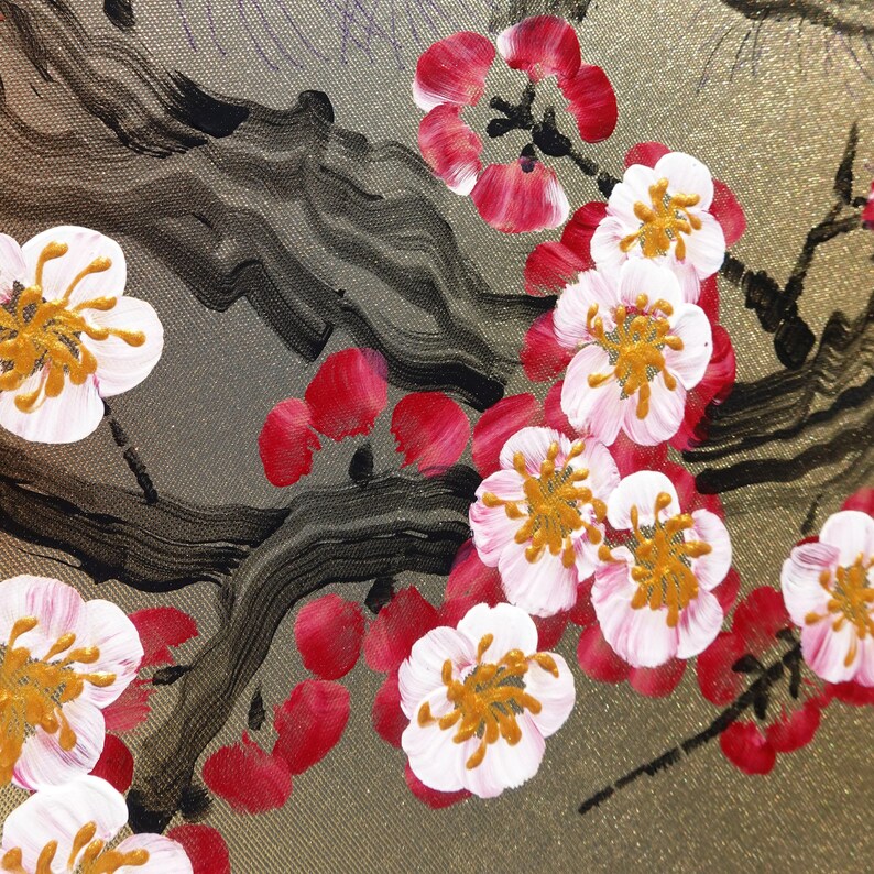 a close-up view of a painting of a branch with pink and white flowers, along with some black and red brushstrokes.